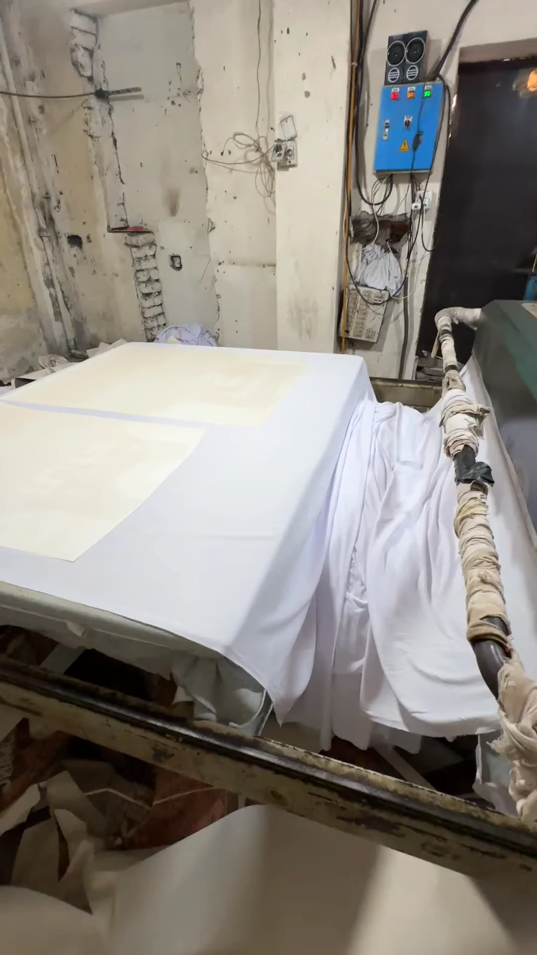 Fabric running through a heat press at ZALI, a custom sportswear manufacturer in Sialkot